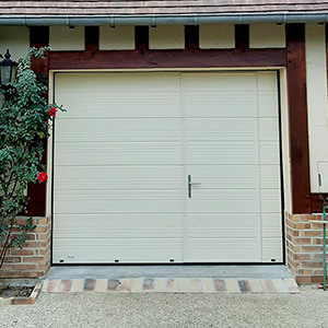 Belle porte de garage à portillon piéton intégré.